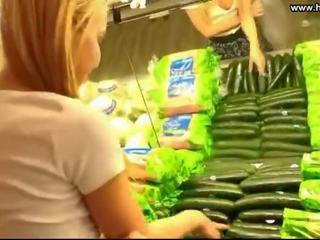Jeune femme baise concombre en publique supermarket